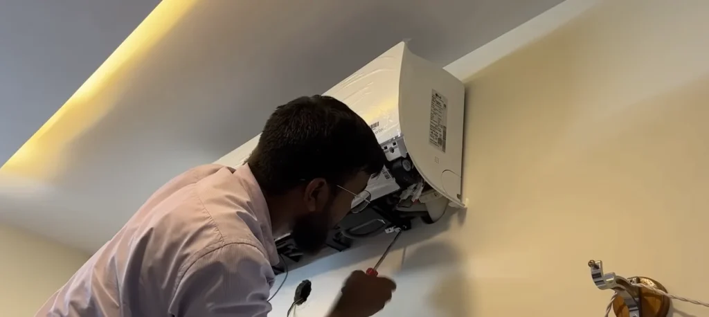 Technician installing a wall-mounted ductless mini-split head