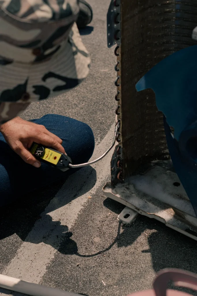 Technician testing the electrical components of an air conditioner during an urgent repair