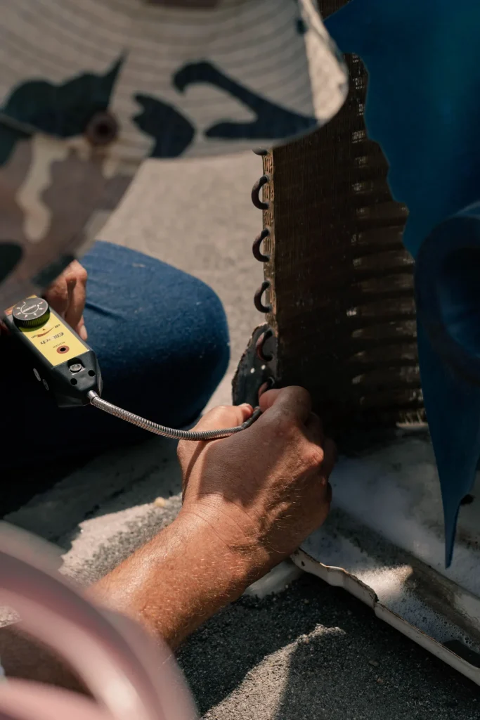 AC technician using tools on refrigerant lines during a repair