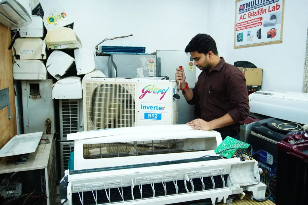 HVAC technician repairing an air conditioner in a workshop