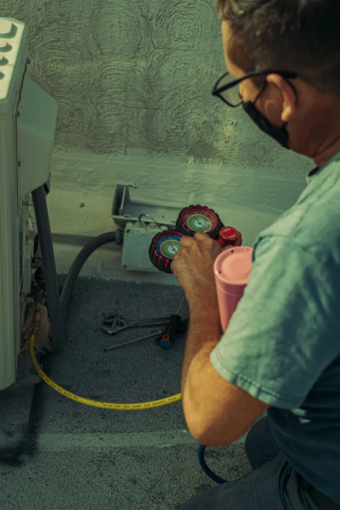 HVAC technician watching gauge readings during an AC performance check